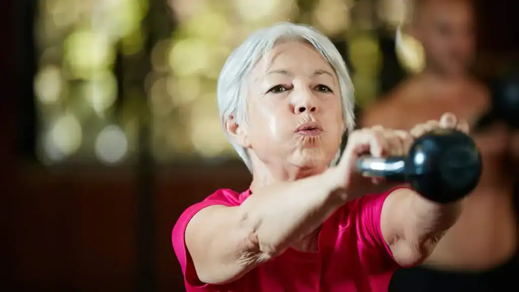 Older woman doing weight training Devizes to help her strength and longevity 