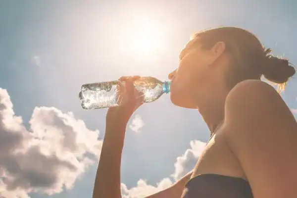 Hydration: The Secret Ingredient for a Toned Stomach and Enhanced Fitness 3 Image of woman drinking water to hydrate Devizes after run.